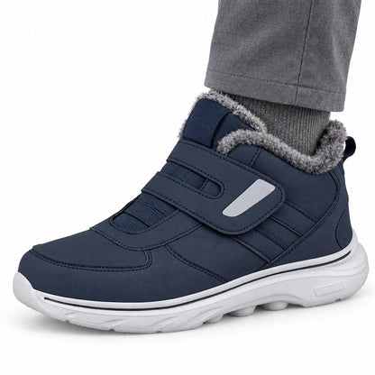 Dunkelblauer Winterschuh mit Klettverschluss am Fuß auf weißem Hintergrund.