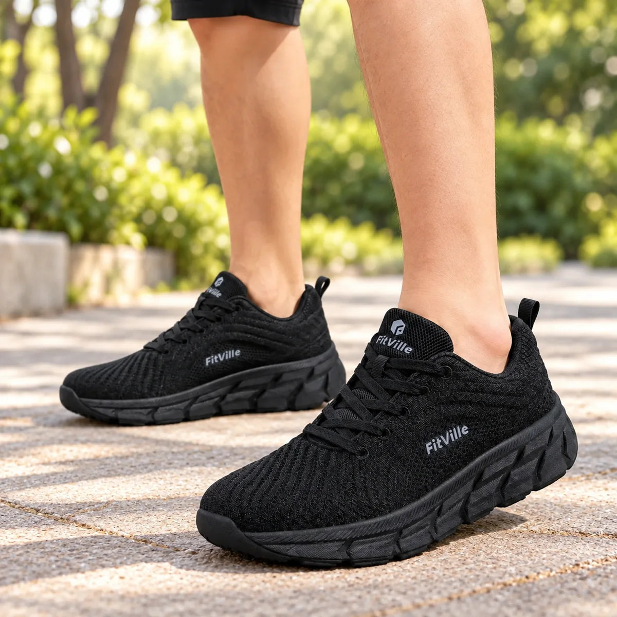 Schwarze Herren-Sneaker beim Tragen auf einem hellen Gehweg.